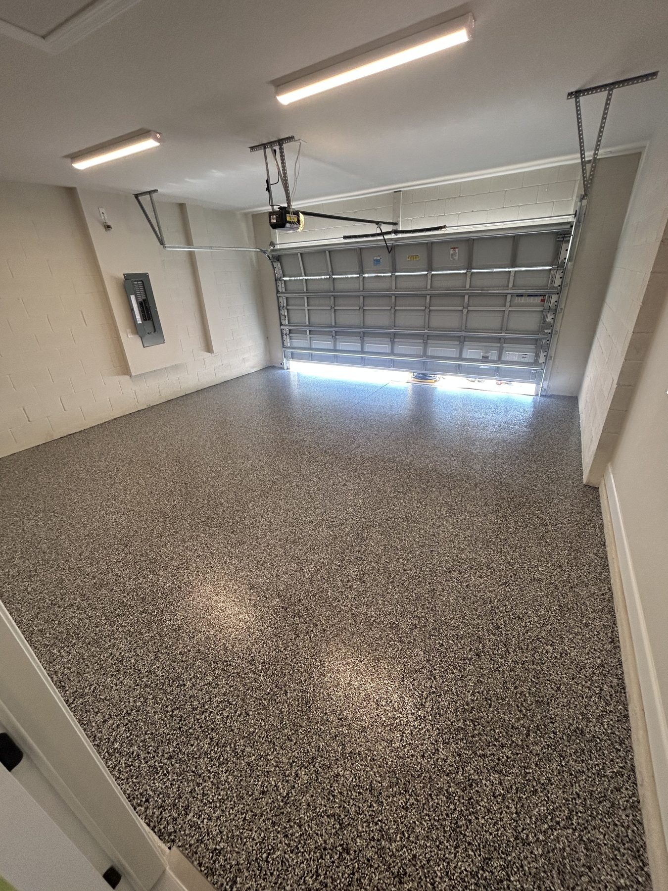 Garage with full-broadcast flake epoxy floor in gray and tan tones