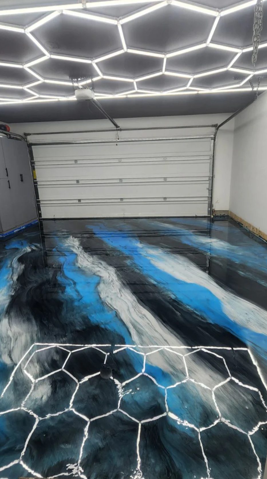 Garage with stunning metallic epoxy floor featuring blue and white swirls